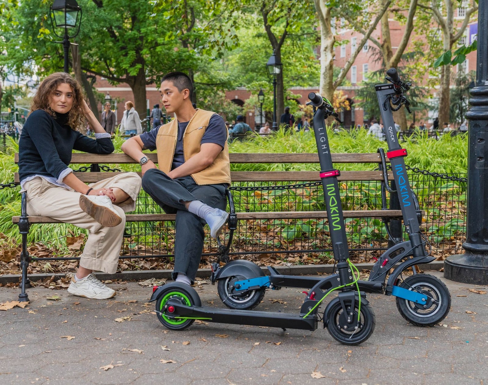 Riders with INOKIM scooters on a city bench